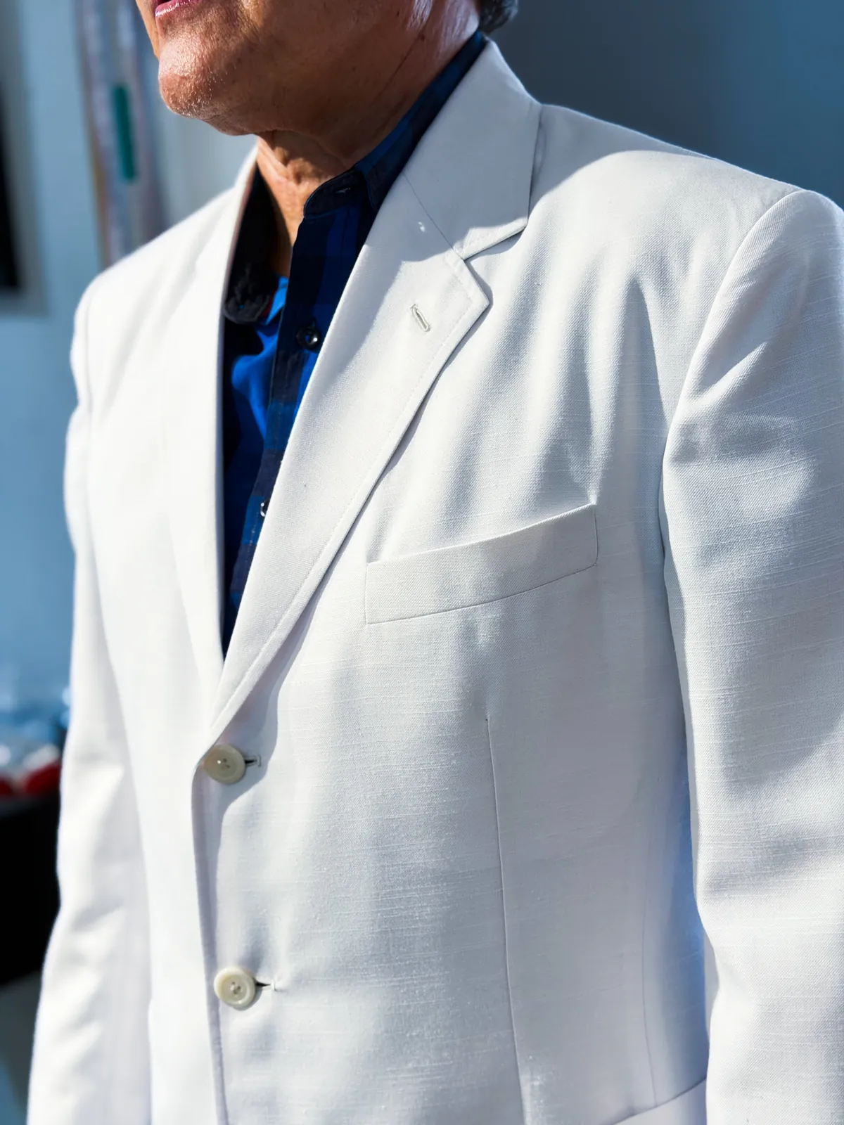 Detalle de saco blanco a medida con camisa azul marino